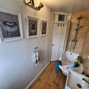 a bathroom with a sink and a white door at Old Road Cottage Pet Friendly Outdoors Beaches in Neath