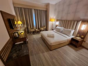 pokój hotelowy z dużym łóżkiem i stołem w obiekcie Vista Square Hotel w Dubaju