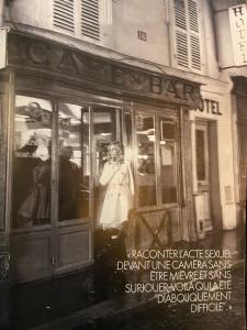 uma foto a preto e branco de um bar com uma mulher na janela em Grand Hôtel de Clermont em Paris