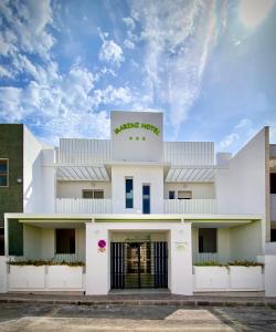 Un bâtiment blanc avec un panneau. dans l'établissement Marini Hotel B&B, à Lido Marini