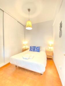 een slaapkamer met een wit bed en 2 nachtkastjes bij Comfortable studio old town, parking optional in Sevilla
