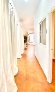 um corredor com portas brancas e pisos de madeira em Comfortable studio old town, parking optional em Sevilha