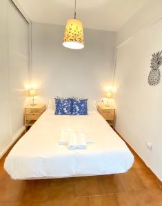um quarto com uma cama branca com duas toalhas em Comfortable studio old town, parking optional em Sevilha