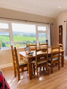 ein Esszimmer mit einem Tisch, Stühlen und einem Fenster in der Unterkunft Private 3 bedroom house ideal for family & friends in Killybegs