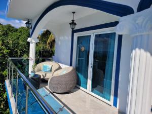 a balcony with a chair and a glass door at casaenjoysamana in Los Naranjos
