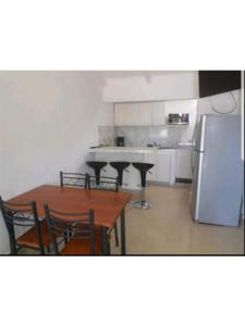 a kitchen with a table and chairs and a refrigerator at Condominio Tropical villa 2 in Jacó