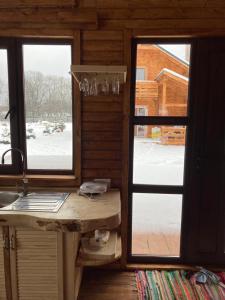 a kitchen with two windows and a sink and a counter at La Cabane Râșnov in Râşnov