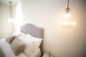 a room with a white couch with pillows and two lights at No 1 The Turret in Kelso
