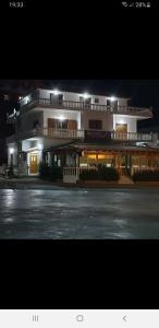 un gran edificio con un estacionamiento por la noche en Hotel Lagjini, en Lukovë