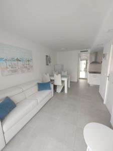 a white living room with a white couch and blue pillows at Rizi Corralejo Sun in Corralejo
