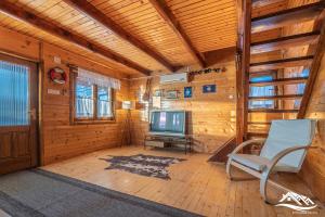 a living room with a television and a chair at Holiday Home Zorić in Nik&scaron;ić