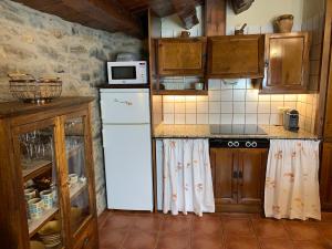 a kitchen with a white refrigerator and a microwave at Casa Rural Torre Gargallo in Morella