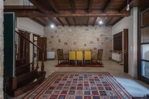 a living room with a table and chairs and a brick wall at Kourtis Family Mansion in Karpenision