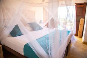 1 dormitorio con cama con dosel y almohadas azules en Hotel Boutique Venturi, en Barichara