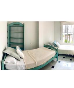 sypialnia z dwoma łóżkami piętrowymi i oknem w obiekcie Apartamento Bahía Jardín w mieście La Herradura