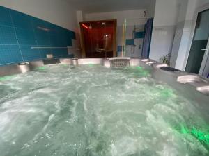 La salle de bains est pourvue d'une grande baignoire remplie d'eau. dans l'établissement Vila Cristal, à Băile Felix