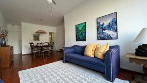 sala de estar con sofá azul y mesa en Amplo e confortável em Pitangueiras en Guarujá