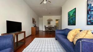 sala de estar con sofá azul y TV en Amplo e confortável em Pitangueiras en Guarujá