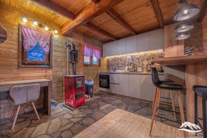 a kitchen with a stove and chairs in a room at Holiday Home Zorić in Nikšić