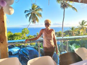a woman standing on a balcony overlooking the ocean at casaenjoysamana in Los Naranjos