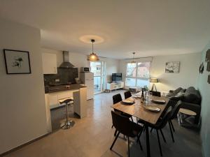a living room and kitchen with a table and chairs at Appartement Magnîolia proche centre Ville in Colmar