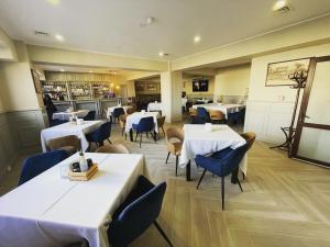 トゥルチャにあるHotel Cityの白いテーブルと青い椅子が備わるレストラン