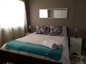 1 dormitorio con 1 cama blanca grande y ventana en Donde brilla el sol en Dina Huapi