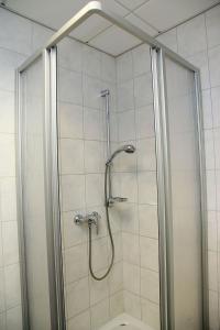 a shower with a glass door in a bathroom at Pension am Markt in Lübben