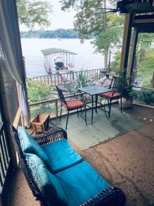 a couch on a porch with a view of the water at Lake Home by Nashville- Hot tub, swim, fish in Hendersonville