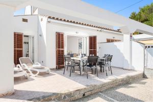 a white house with a table and chairs on a patio at Casa Hawaii in Port d'Alcudia