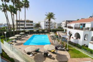 an overhead view of a swimming pool with chairs and umbrellas at Playamar Bungalows in Playa del Ingles