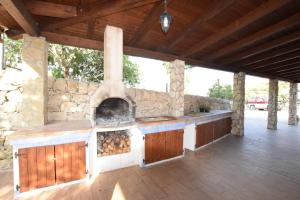 Una gran cocina al aire libre con una pared de piedra. en Ceretanum Holiday House, en Giarratana