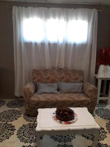 a living room with a couch in front of a window at Donde brilla el sol in Dina Huapi