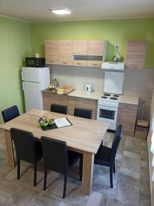 una cucina con tavolo e sedie in legno di Apartman FiVa2 a Pačir