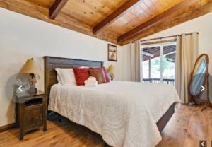 - une chambre avec un grand lit et un plafond en bois dans l'établissement Apple Belle Cabin Mountain Escape, à Oakhurst