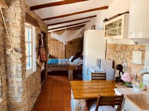 a kitchen with a table and a room with a bedroom at João Jungle in Açafora
