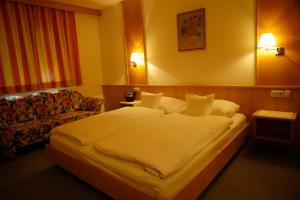 a hotel room with a large bed and a couch at Haus Acherkogel in Tumpen