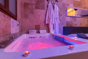 een groot bad met rode verlichting bij BED & SPA - LA PARENTHESE Topdestination-Dijon - Centre ville - classé 3 étoiles in Dijon