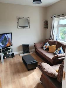 a living room with a couch and a flat screen tv at Private 3 bedroom house ideal for family & friends in Killybegs