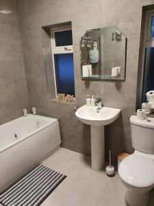a bathroom with a sink and a toilet and a bath tub at Private 3 bedroom house ideal for family & friends in Killybegs