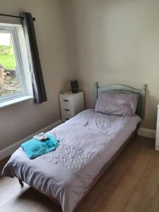 um pequeno quarto com uma cama e uma janela em Private 3 bedroom house ideal for family & friends em Killybegs