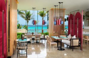 a restaurant with tables and chairs and a view of the ocean at Paradisus Cancun All Inclusive in Cancún