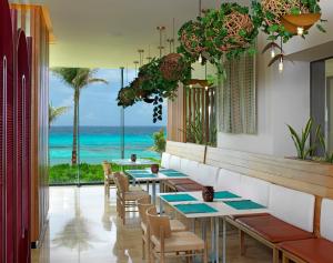 a restaurant with tables and chairs and a view of the ocean at Paradisus Cancun All Inclusive in Cancún