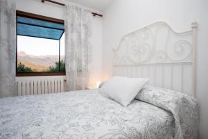 a bedroom with a white bed with a window at OLIVAR de S’HERETAT Trekking/ruta GR-221 (ETV/2099) in Sóller +21 photos