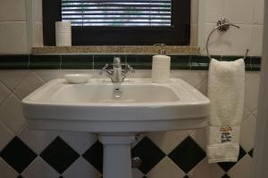 lavabo blanco en un baño con ventana en Modern house - air cond, free parking, breakfast, en Vila Nova de Gaia