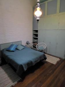 a bedroom with a bed with blue sheets and a lamp at La Glicina casa in La Plata