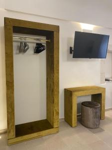 a living room with a tv and a wooden partition with a table at Maison TN appartamento luxury in Ostuni