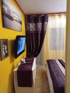 ein Schlafzimmer mit einem Bett und einem TV auf einem Tisch in der Unterkunft boungalow Mena Playmar in San Bartolomé de Tirajana