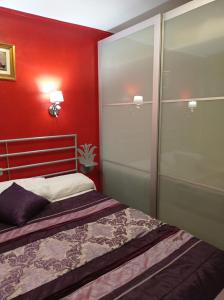 1 dormitorio con cama y pared roja en boungalow Mena Playmar en San Bartolomé