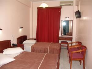a hotel room with two beds and a red curtain at Hotel Cosmos in Athens